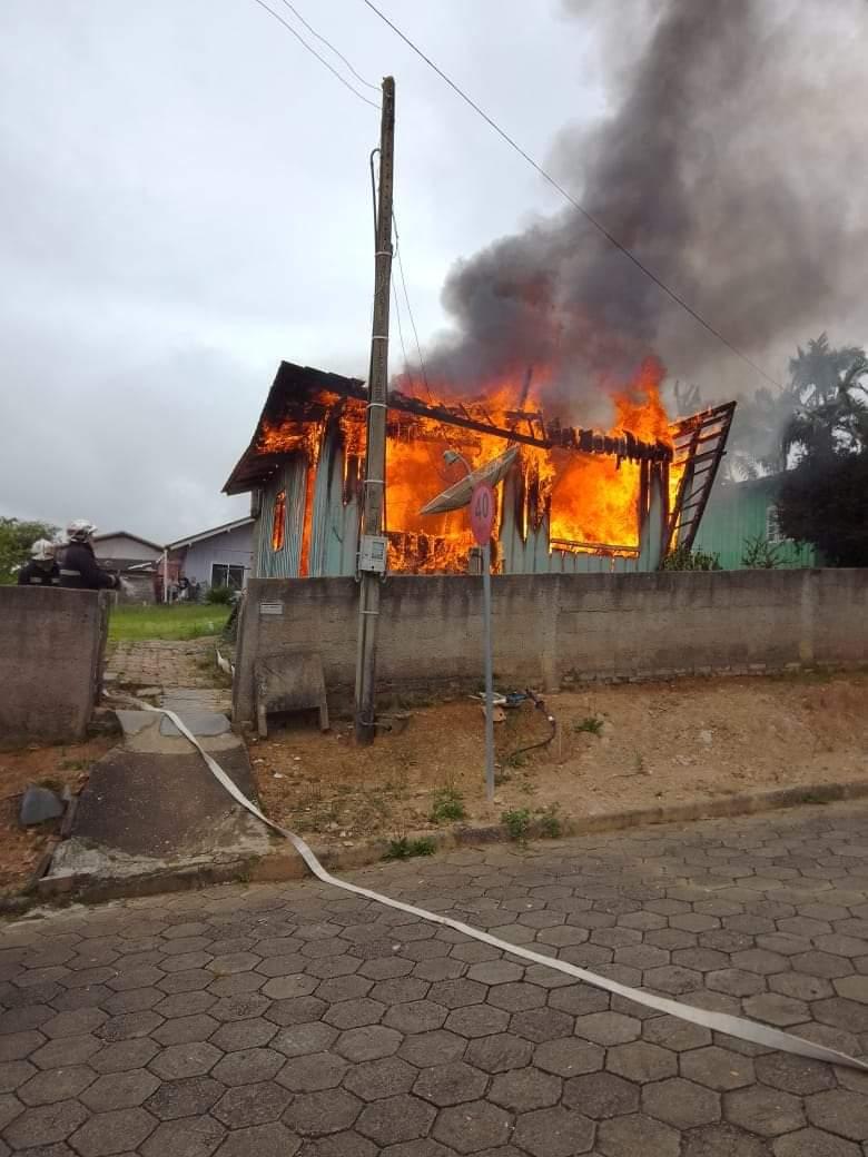 Bombeiros atendendo incêndio em residência.